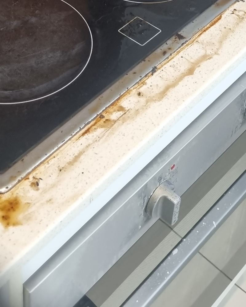Cooktop edge and benchtop before cleaning